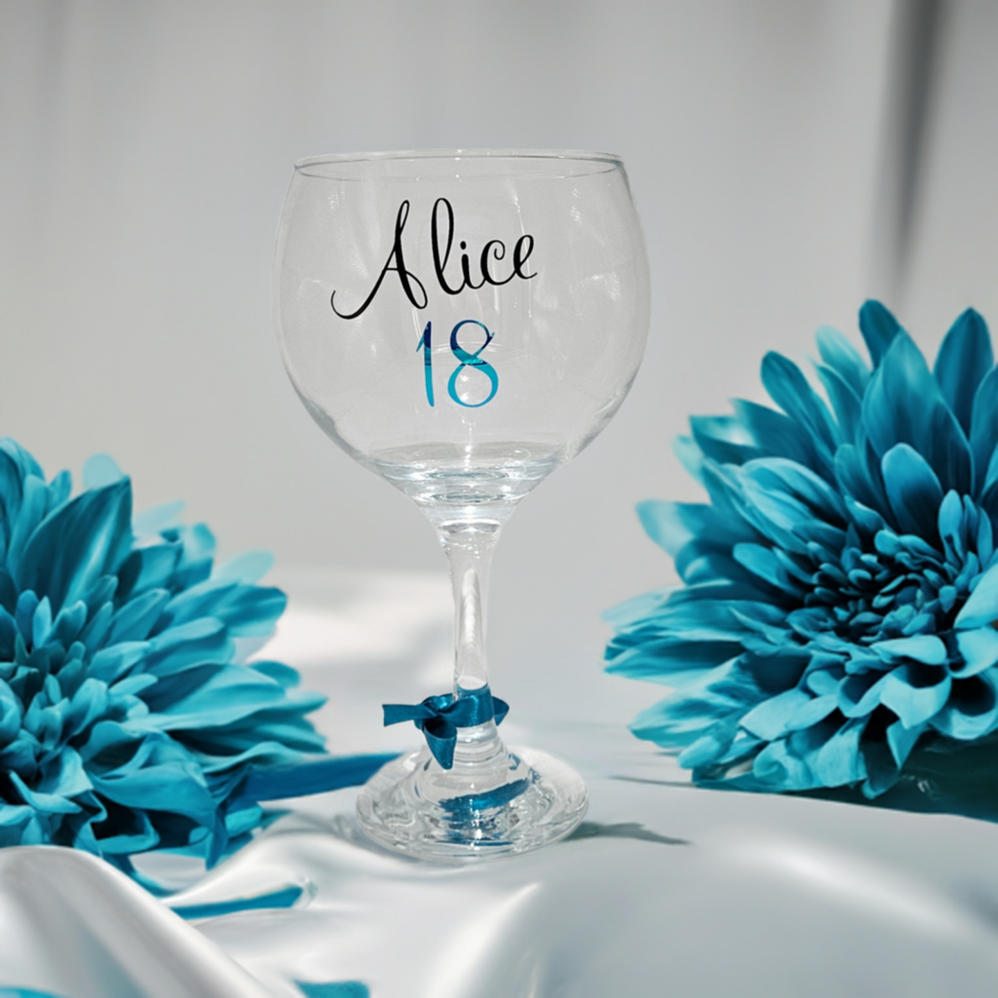 Celebrate her milestone birthday with our luxury keepsake personalised gin & cocktail glass gifts. Designed to mark an 18th, 21st, or any age special birthday. Each personalised with a name in a black script font and an age in a peacock blue chrome vinyl.