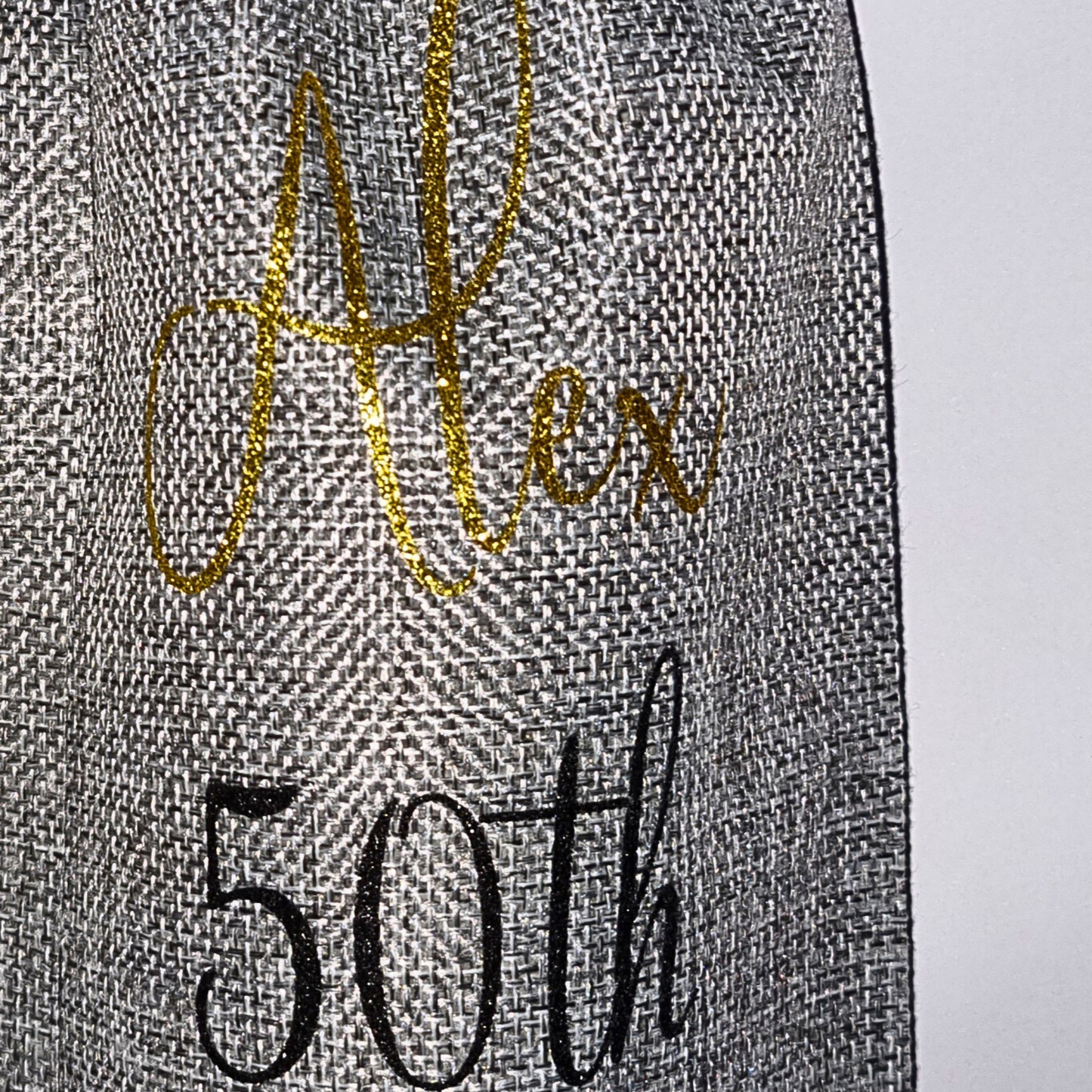 Personalised burlap bottle gift bag with the name 'Alex' in gold glitter vinyl and age '50th' in black vinyl on a white background.
