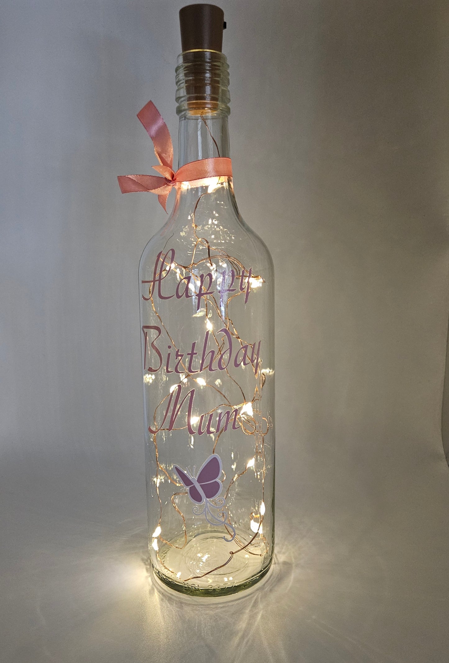 Custom personalised LED bottle with light-up feature, pink butterfly decoration, gift wrapped for any occasion.