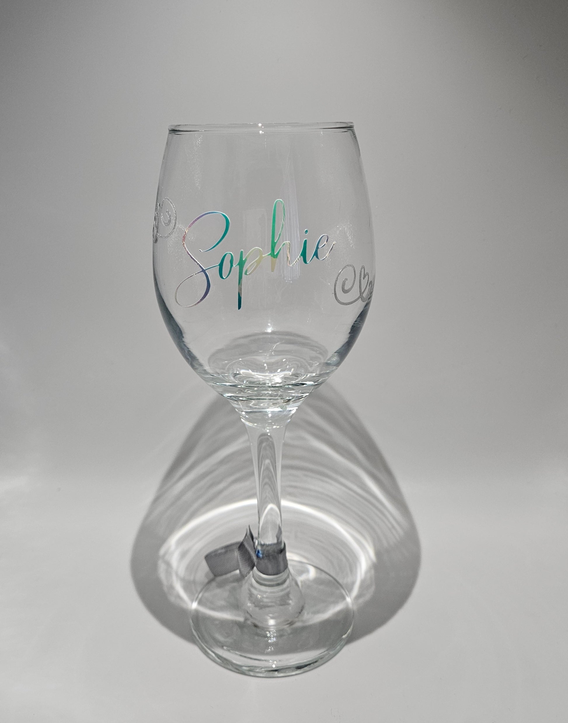 Custom made color-changing wine glass with elegant holographic script design, perfect for birthday gifts, shown with a dynamic iridescent effect in a satin organza gift bag