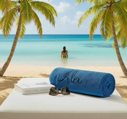 A blue towel on a sunbed with book & sunglasses in a beach scene