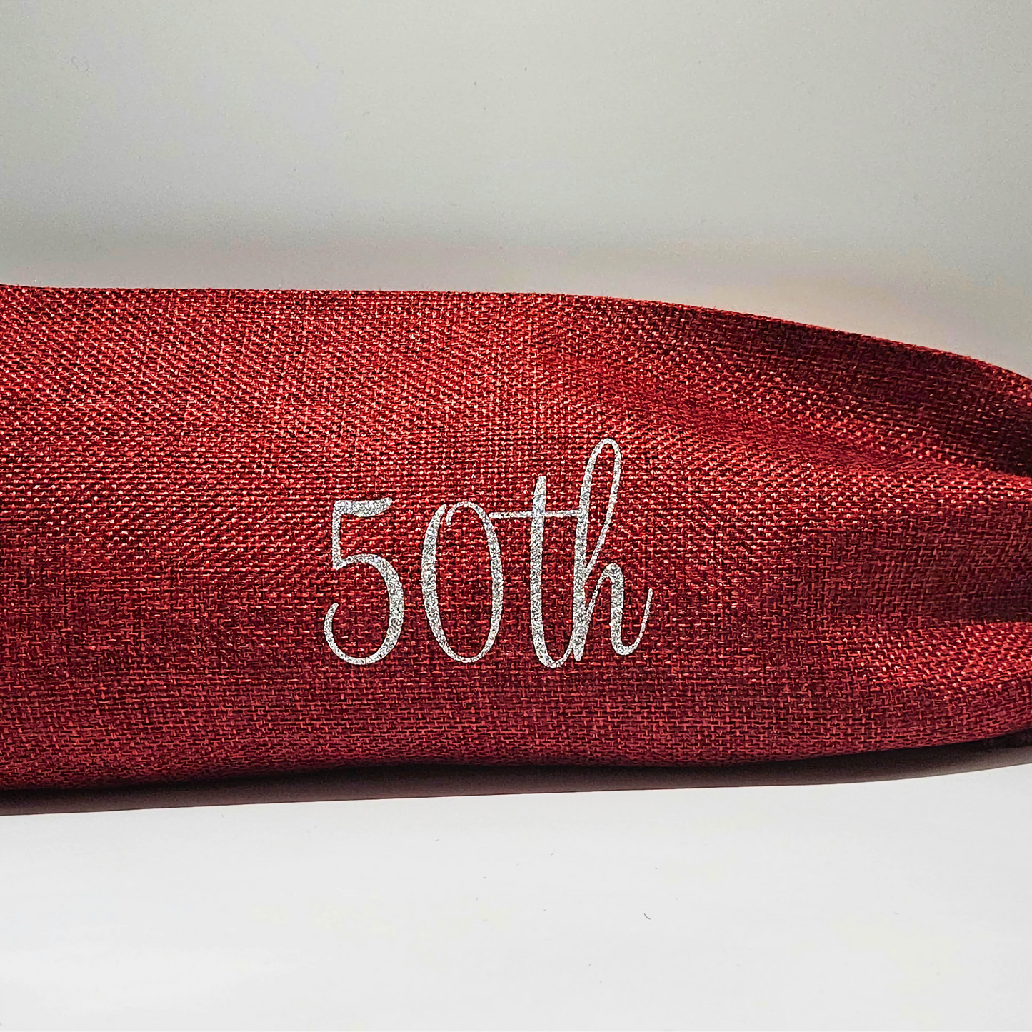 Red burlap bag with '50th' in silver glitter vinyl on a light background