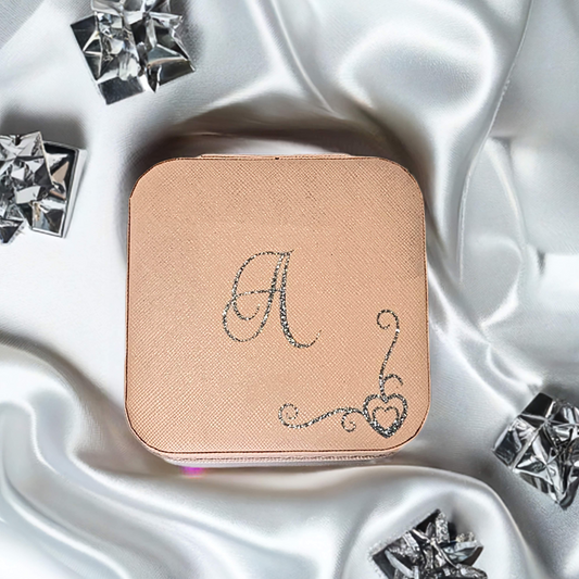 Compact jewellery case with decorative letter 'A' on a satin background