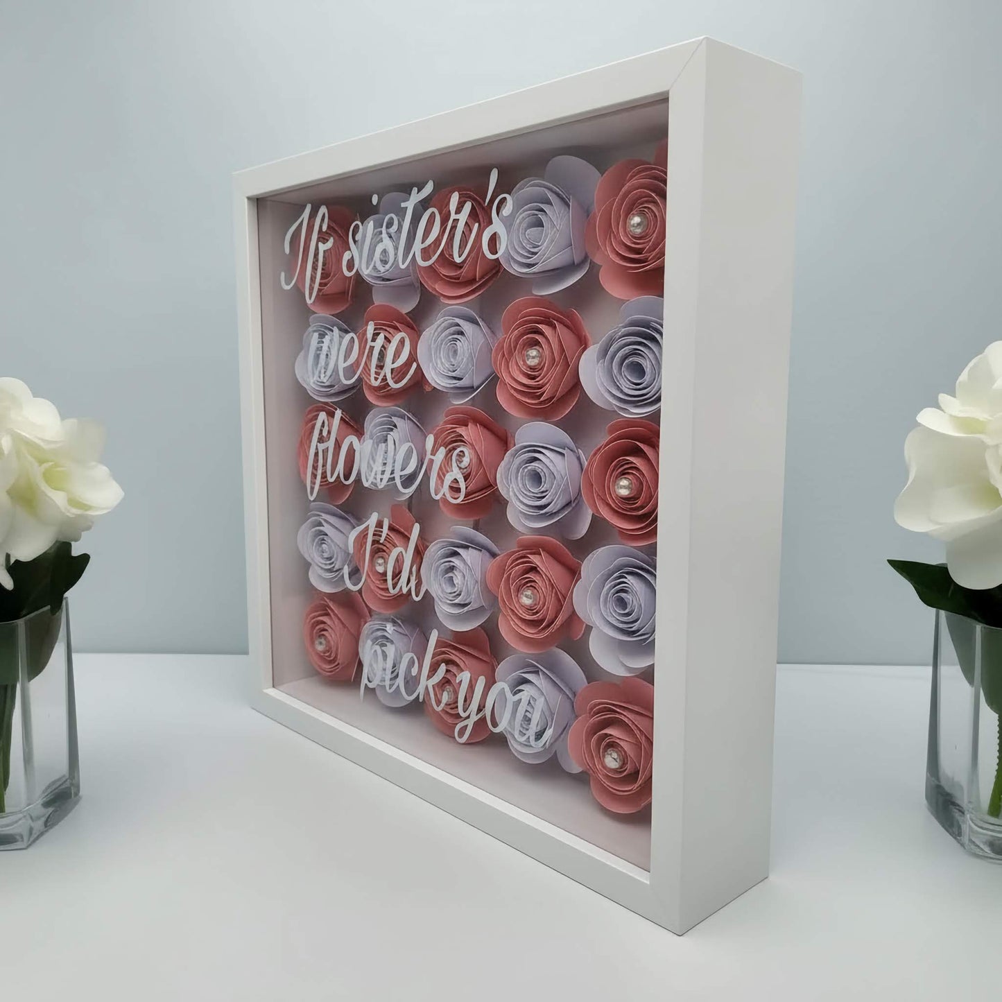 Decorative box with paper flowers and text on a white background