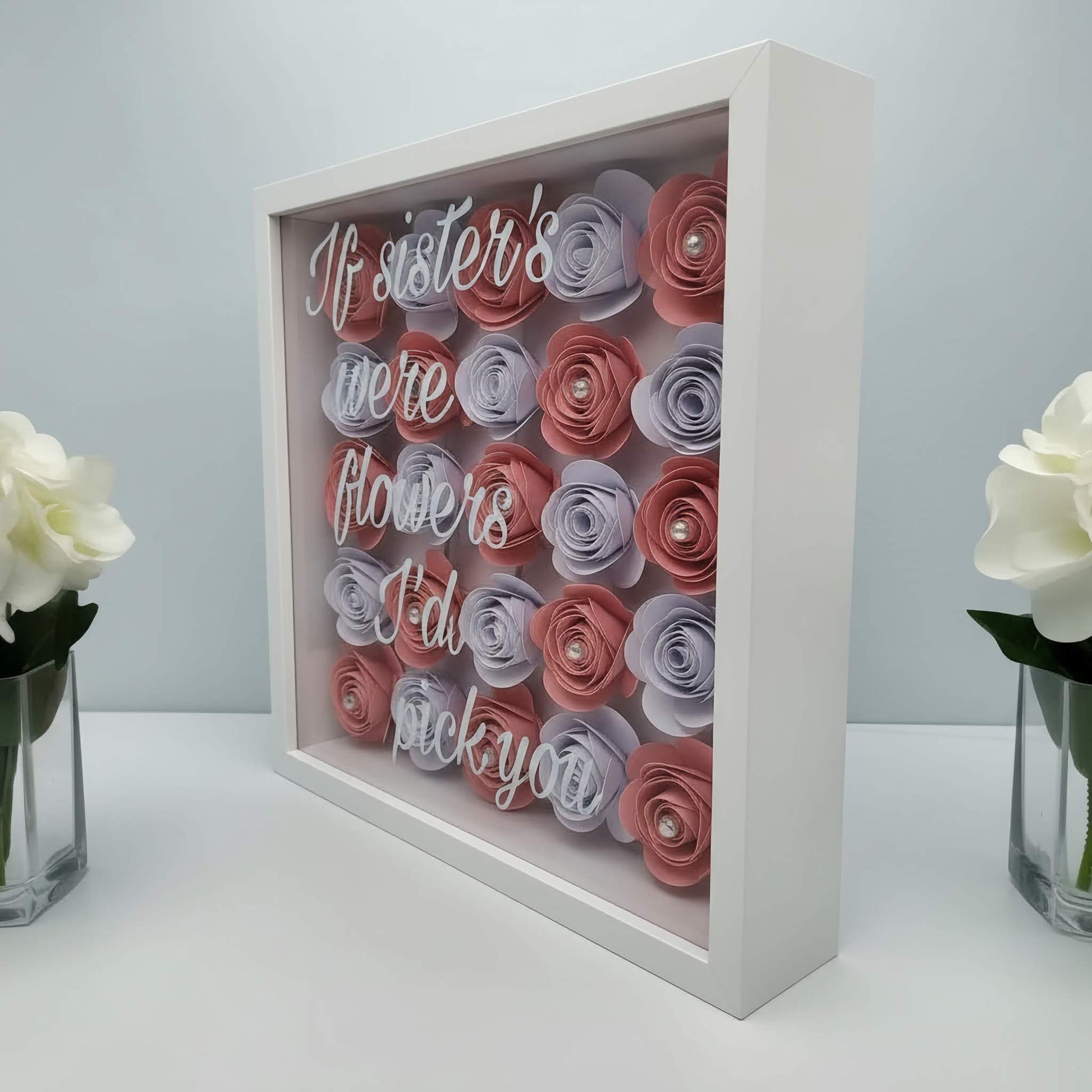 Decorative box with paper flowers and text on a white background