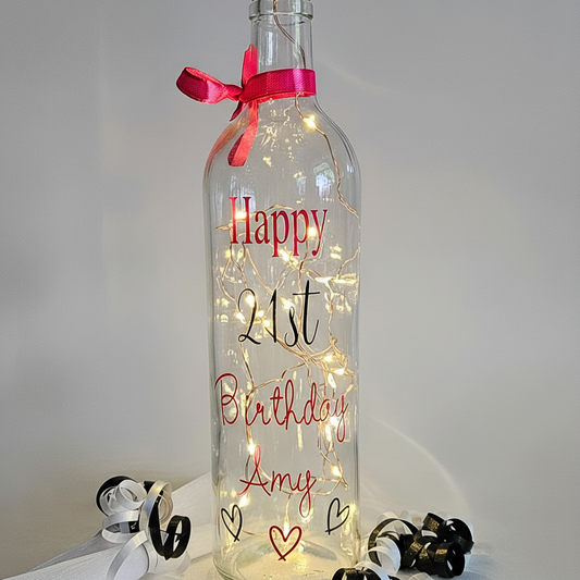 A clear bottle with hearts & lights. Has the wording 'Happy Birthday 21st Amy'