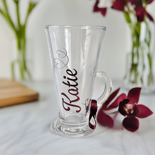 Personalised luxury latte & hot chocolate glass gift for her. Perfect gifts for her birthday, special occasions, and Mother's Day. This clear glass features a name in a burgundy vinyl fresco font and silver glitter heart decoration.